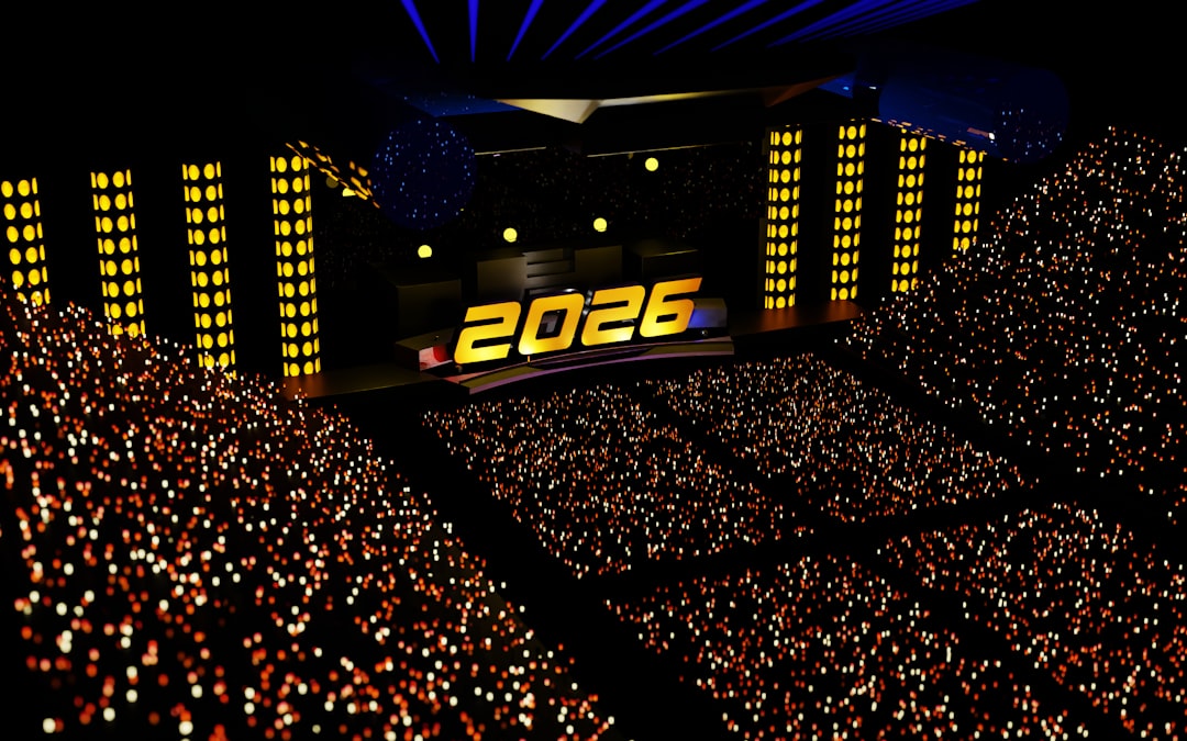 Spectacular New Year 2026 celebration stage with stunning 3D golden text display. Massive concert arena featuring dramatic blue laser beams, illuminated yellow light pillars, and thousands of colorful bokeh lights from the enthusiastic crowd. This futuristic stage production showcases cutting-edge lighting design and immersive atmosphere, perfect for celebrating the arrival of 2026 in grand style.
